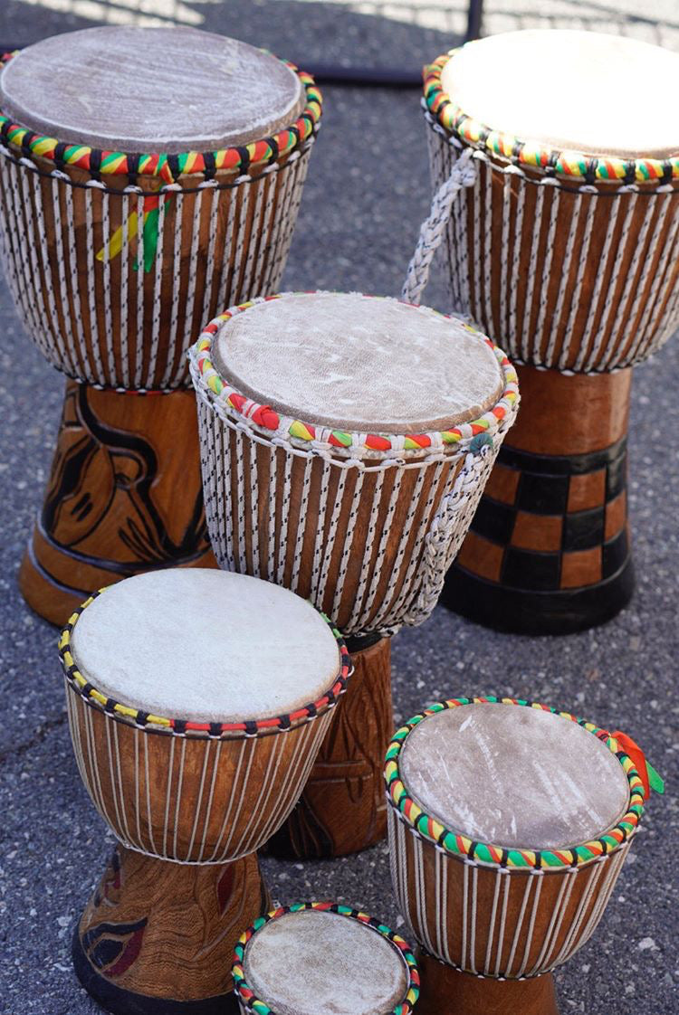 Teranga Africa/Choose Senegal collection of hand-carved wooden djembe drums with goatskin heads and colorful trim.